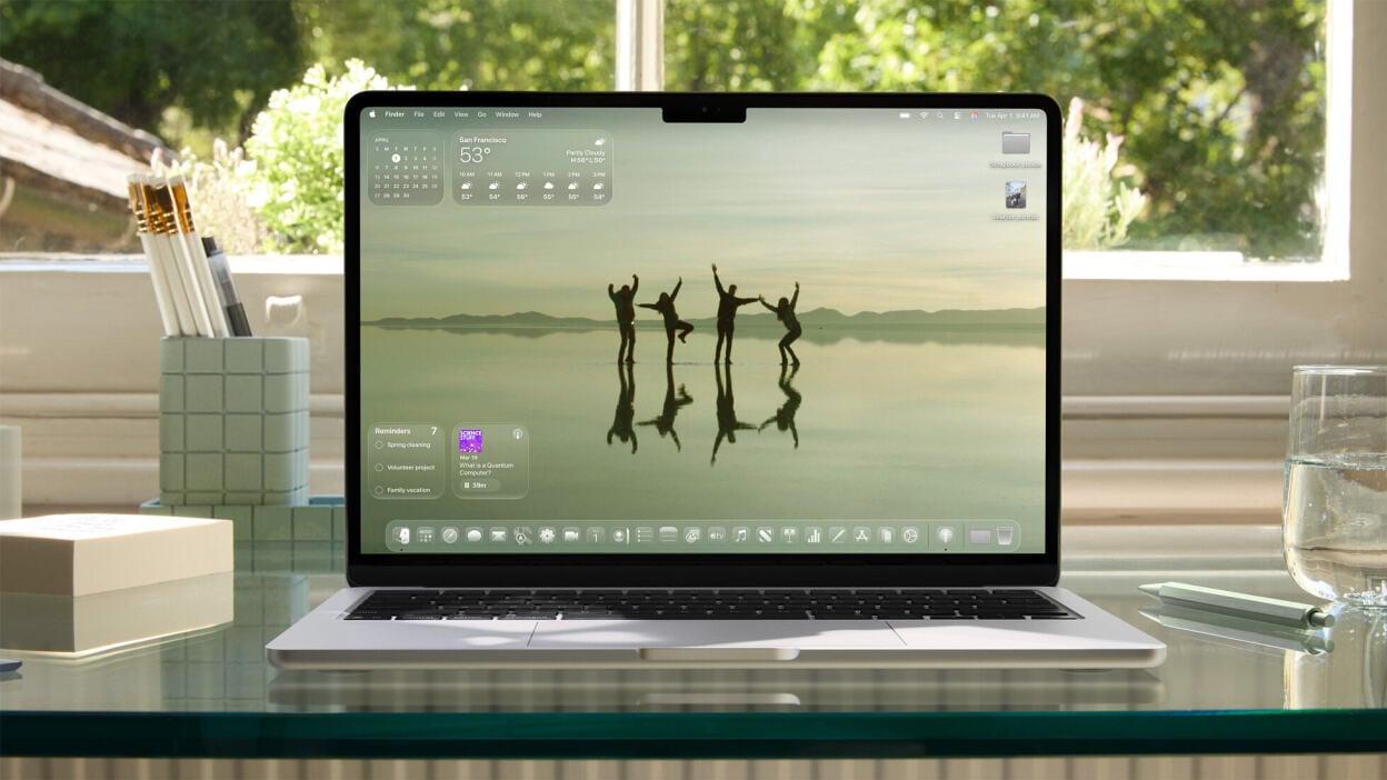 A photograph of a Mac laptop displaying the new MacOS 26 operating system. 