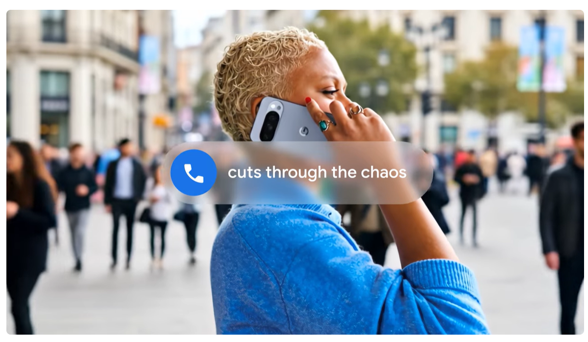 A person talking on the phone in a busy city street, with a notification on the screen saying "cuts through the chaos," highlighting the phone’s AI-enhanced noise cancellation feature.