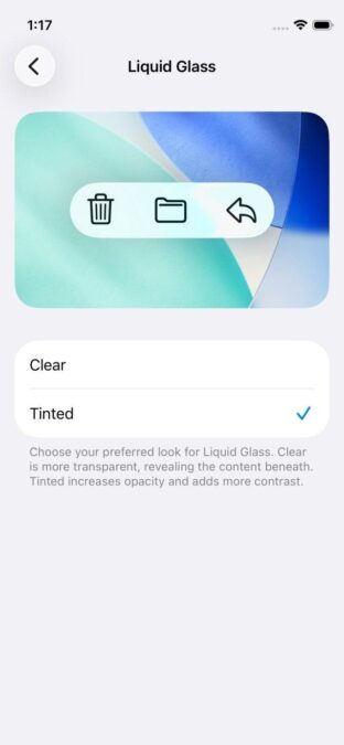 Mobile interface showing customization options for a feature called "Liquid Glass." The screen displays the time as 1:17 and includes a preview image with abstract colors and three icons: delete, save, and share. Below the preview, two selectable options—"Clear" and "Tinted"—are shown, with "Tinted" currently selected. A description explains that "Clear" offers more transparency, while "Tinted" adds opacity and contrast.