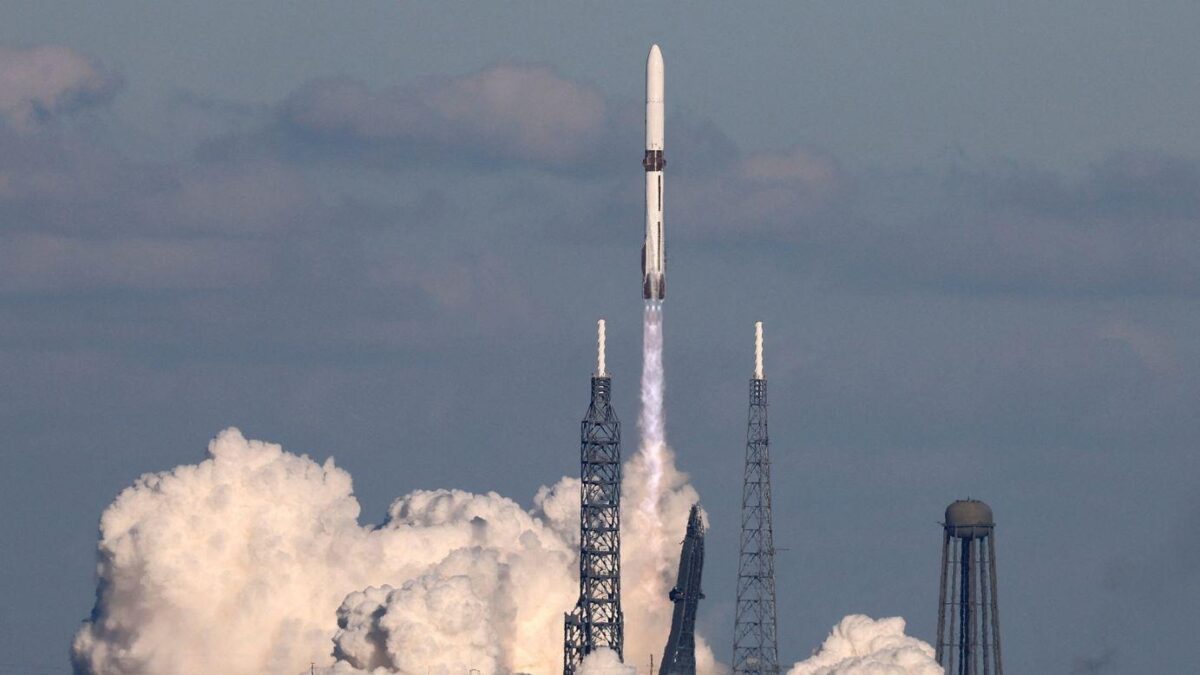 Rocket launching with clouds of smoke and steam rising from the launch pad, with the rocket ascending into the sky.